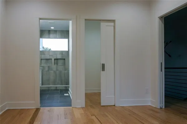 an empty room with wooden floor and entrance