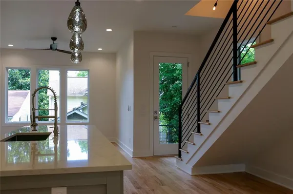 a view of a hallway with wooden floor and staircase