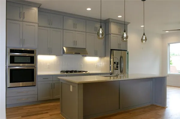 a kitchen with granite countertop a stove and a refrigerator