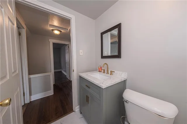 a bathroom with a toilet a sink and mirror