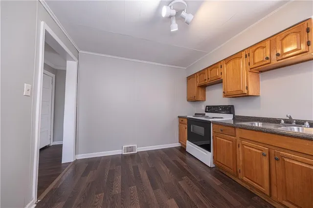 a kitchen with sink a stove and cabinets