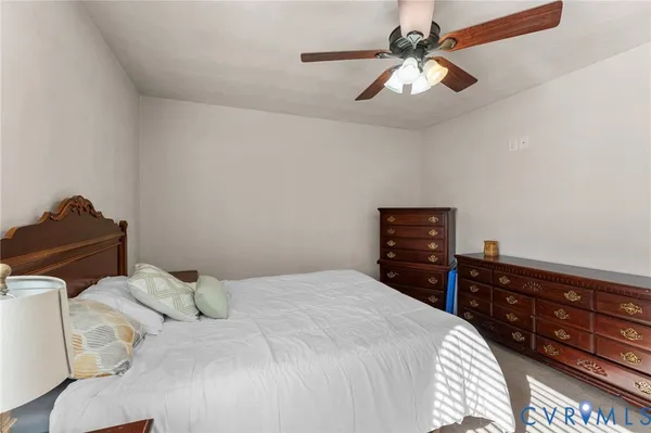 a bedroom with a bed a chandelier and a window