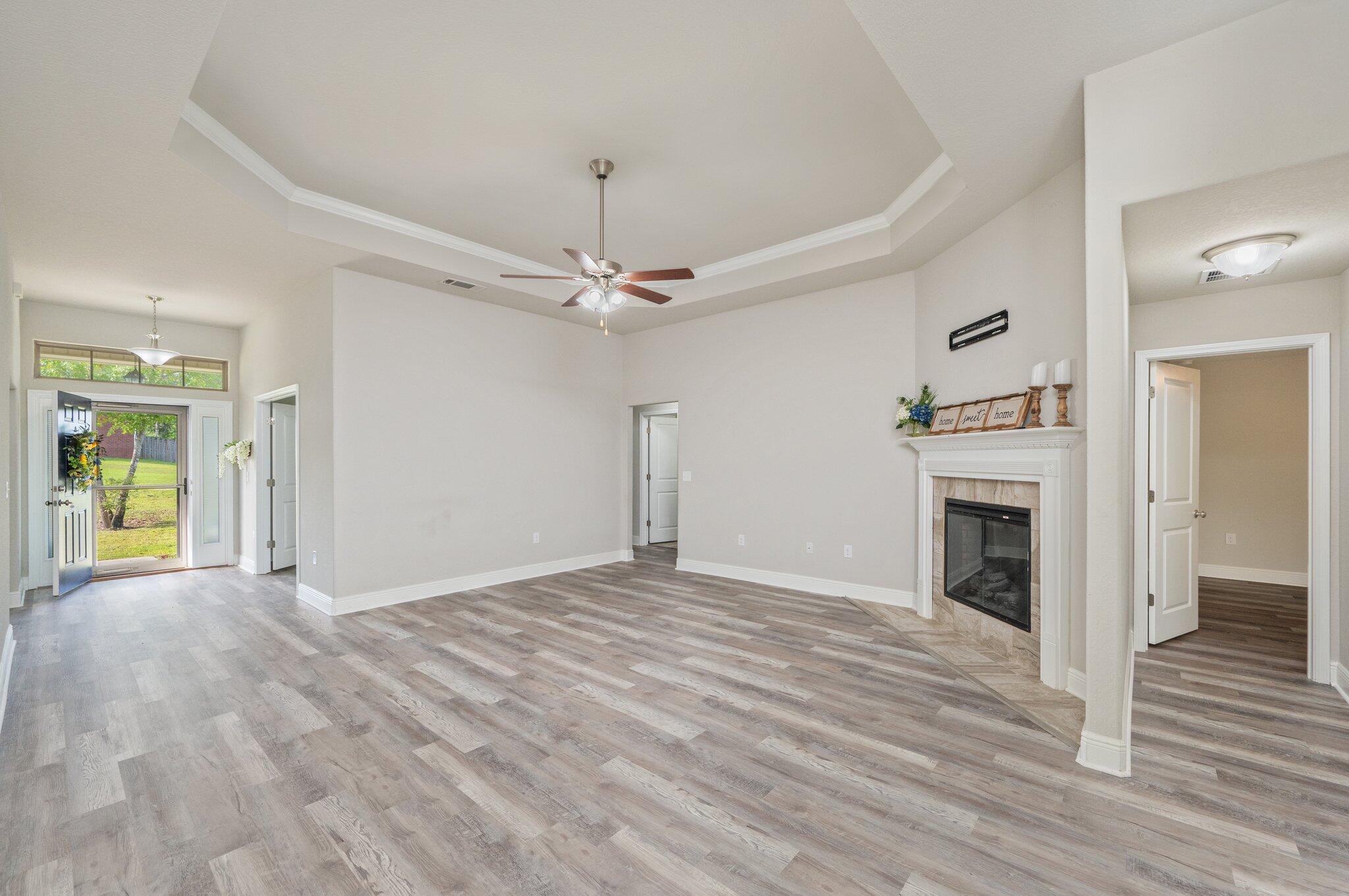 605 Terrier Trail Crestview, FL 32536 - Photo 13 of 46 a view of an empty room with wooden floor fireplace and a window