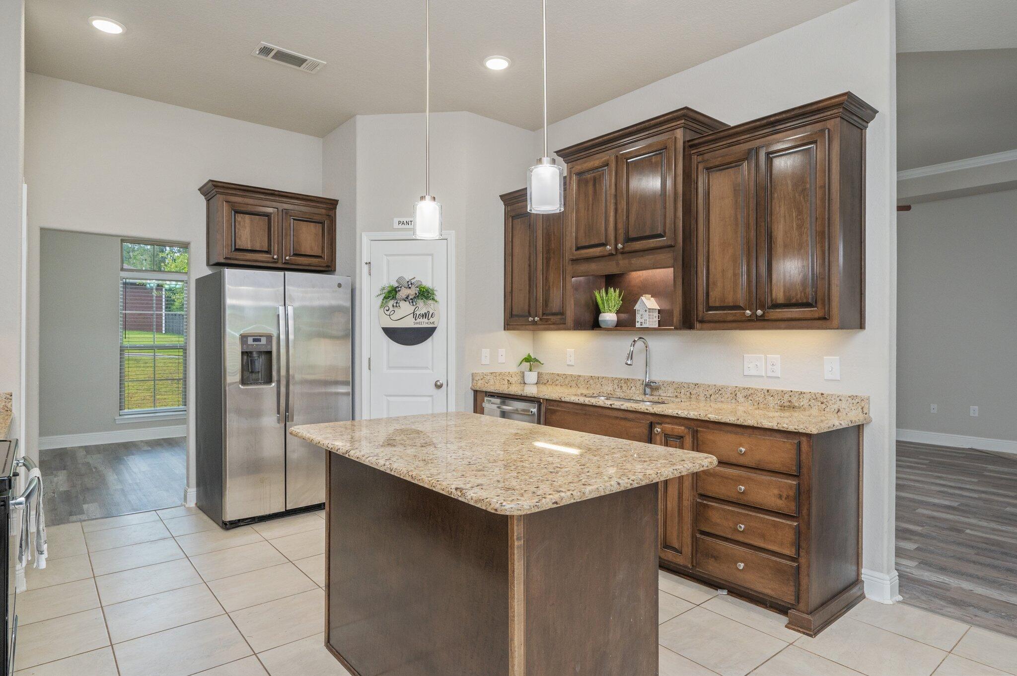 605 Terrier Trail Crestview, FL 32536 - Photo 16 of 46 a kitchen with stainless steel appliances granite countertop a sink and a refrigerator