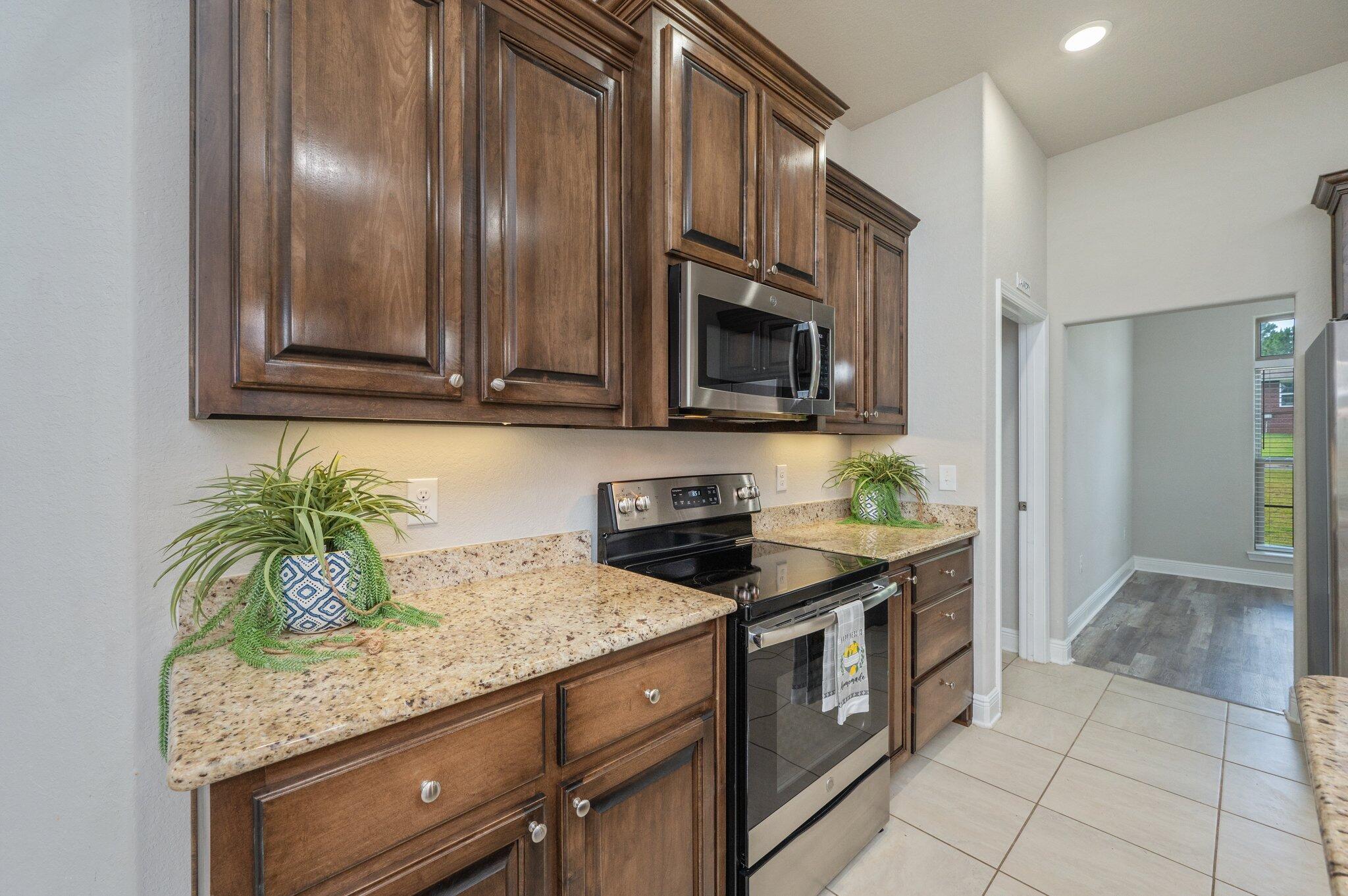 605 Terrier Trail Crestview, FL 32536 - Photo 18 of 46 a kitchen with stainless steel appliances granite countertop a stove a microwave and refrigerator