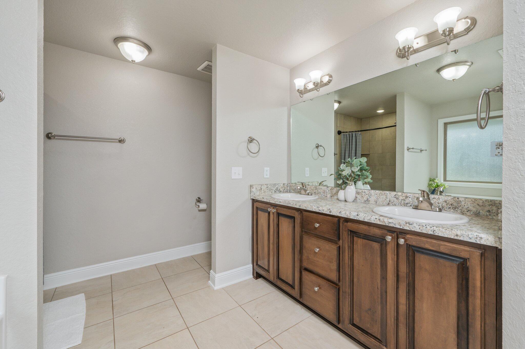 605 Terrier Trail Crestview, FL 32536 - Photo 24 of 46 a bathroom with a granite countertop sink a large mirror and a shower