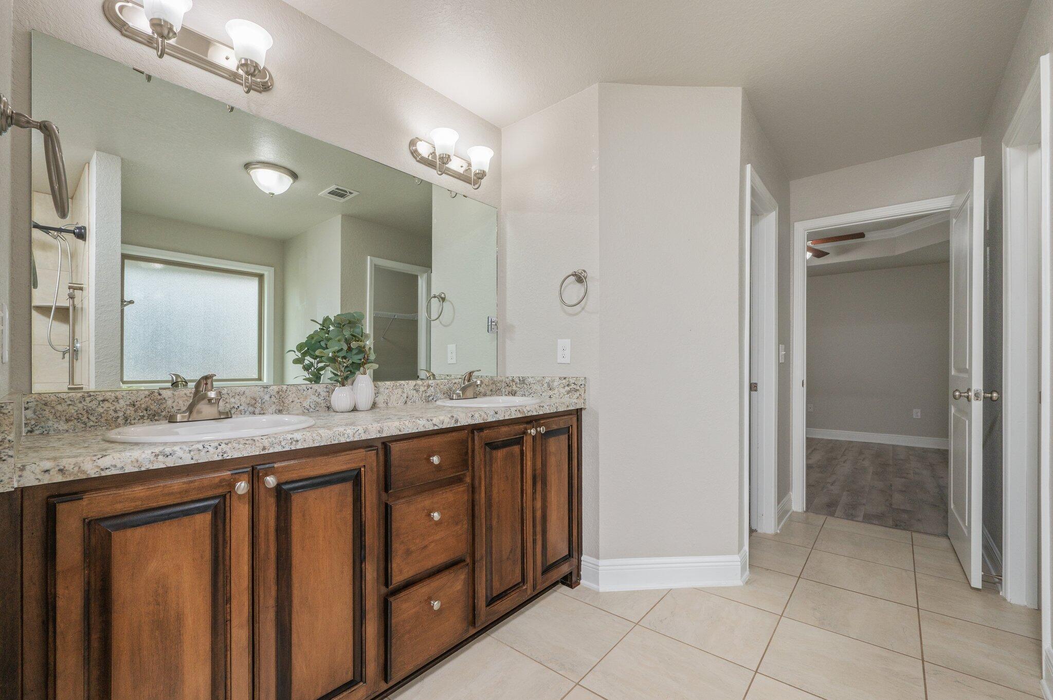 605 Terrier Trail Crestview, FL 32536 - Photo 27 of 46 a bathroom with a granite countertop sink a mirror and a shower
