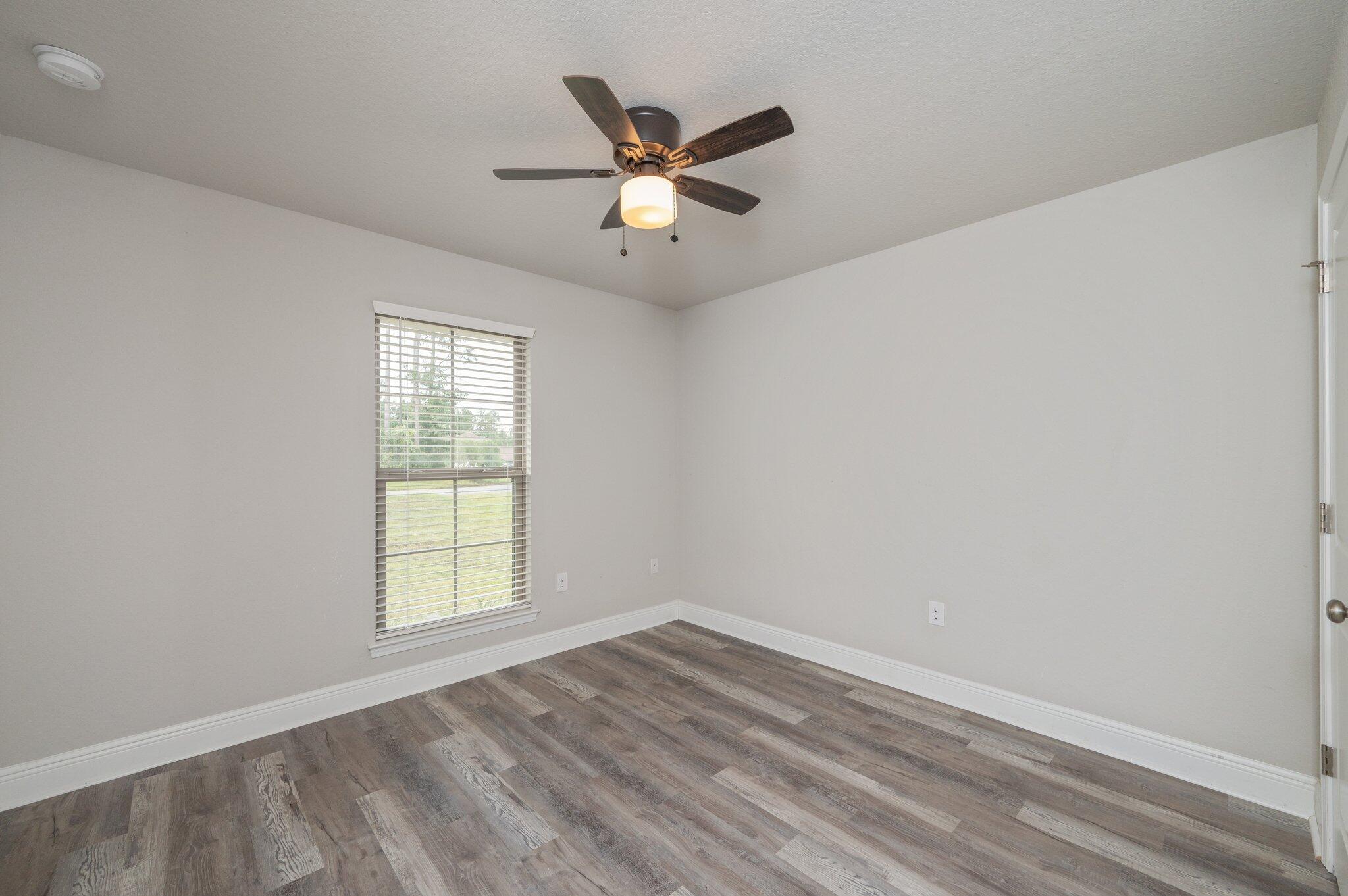 605 Terrier Trail Crestview, FL 32536 - Photo 33 of 46 wooden floor in an empty room with a window