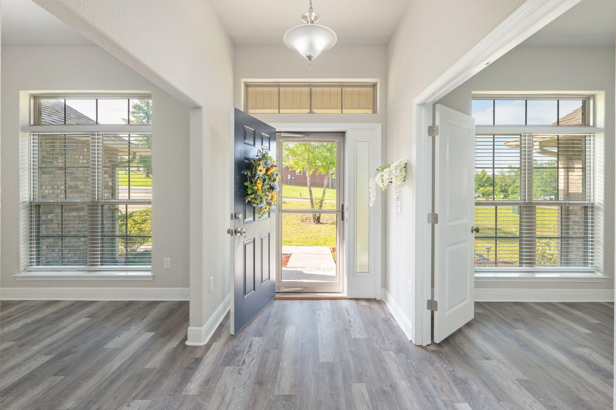 605 Terrier Trail Crestview, FL 32536 - Photo 6 of 46 an empty room with wooden floor and windows