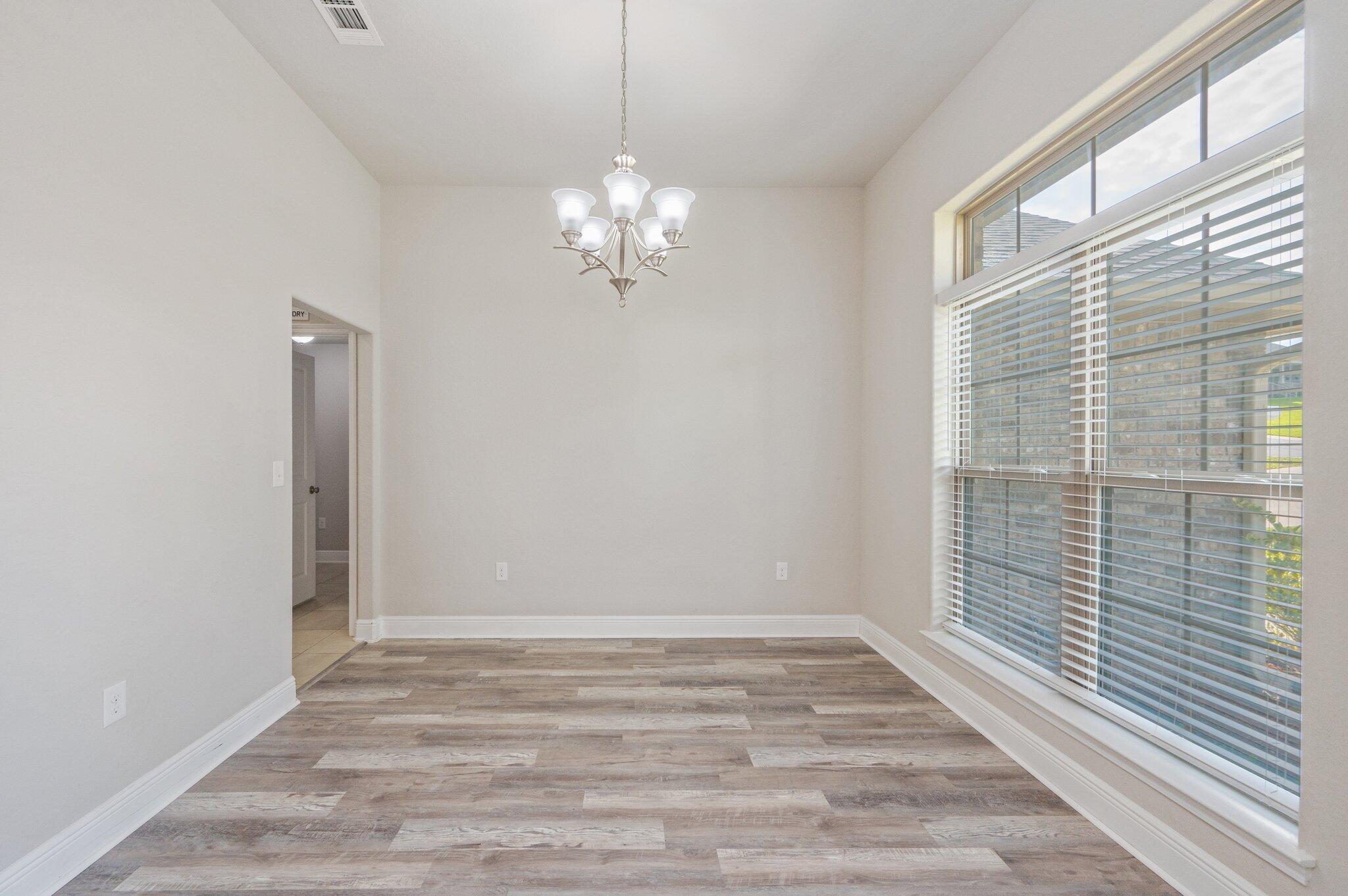 605 Terrier Trail Crestview, FL 32536 - Photo 8 of 46 a view of a chandelier fan and wooden floor