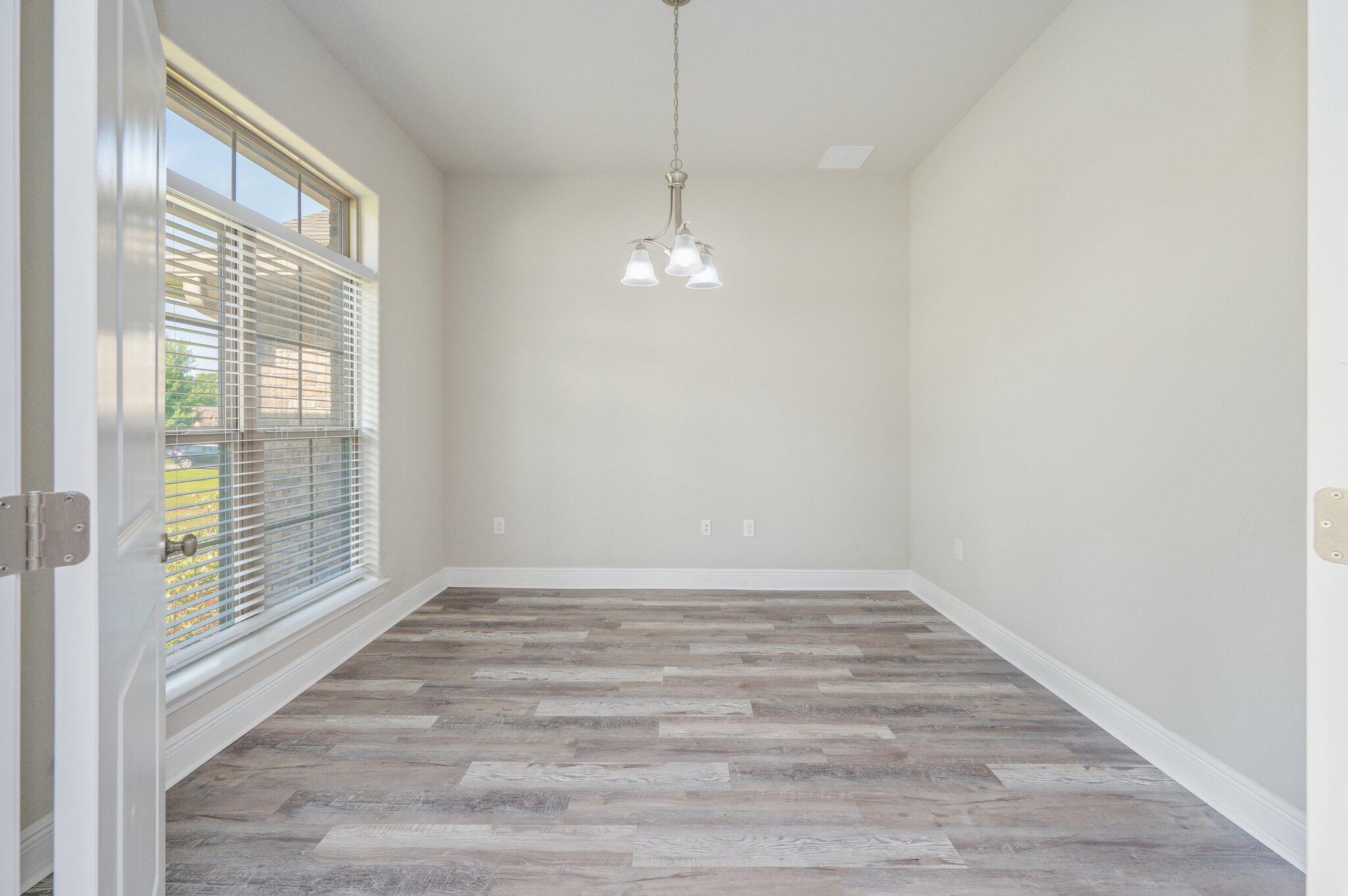 605 Terrier Trail Crestview, FL 32536 - Photo 9 of 46 a view of an empty room with wooden floor and a window