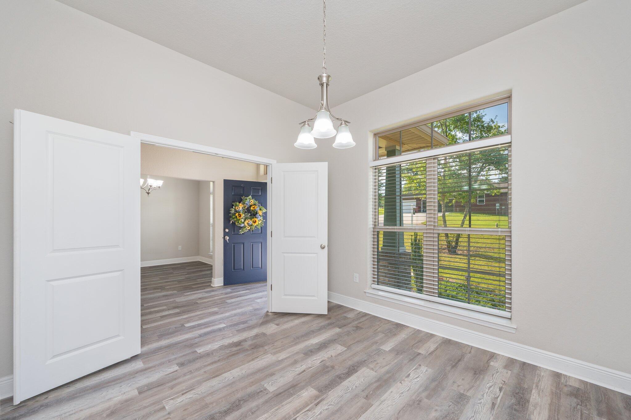 605 Terrier Trail Crestview, FL 32536 - Photo 10 of 46 an empty room with wooden floor and windows