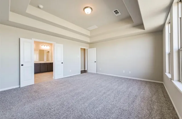 an empty room with an entryway and windows