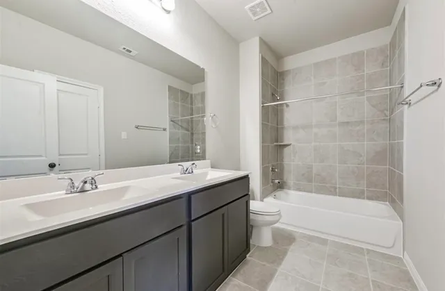 a bathroom with a double vanity sink and mirror with bathtub