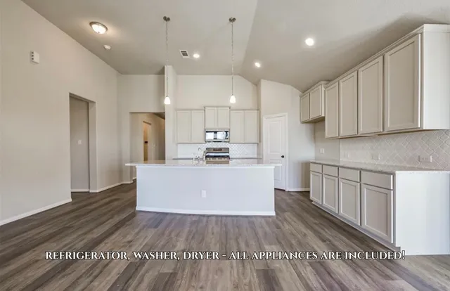 a large kitchen with cabinets wooden floor and stainless steel appliances