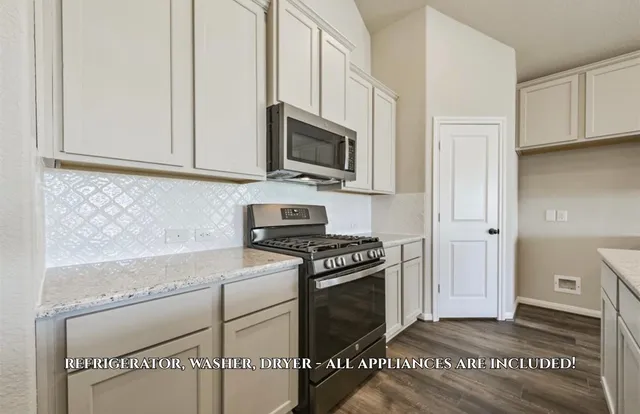 a kitchen with stainless steel appliances granite countertop a stove a sink and a microwave