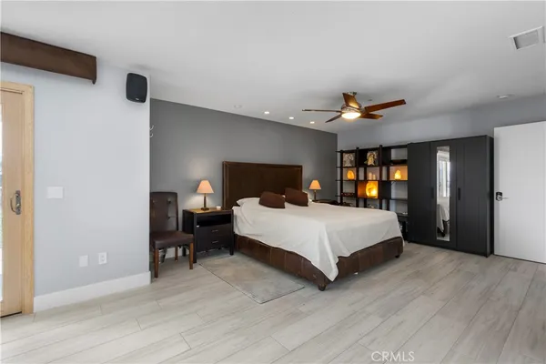 a spacious bedroom with a bed and a large mirror