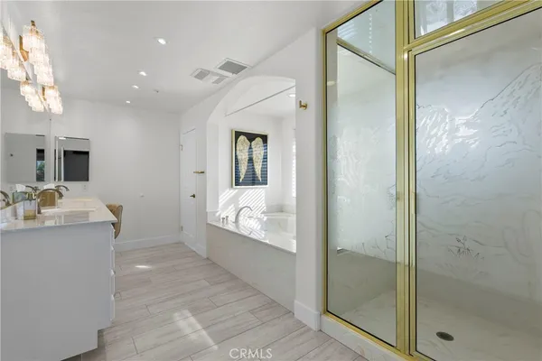 a bathroom with a tub sink and mirror