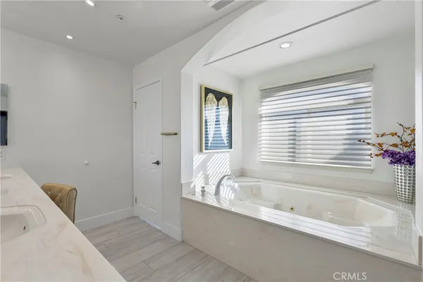 a white bath tub sitting in a bathroom next to a window