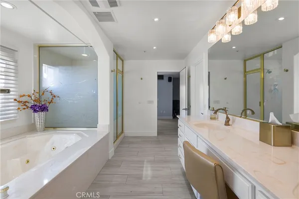 a spacious bathroom with a bathtub shower sink and mirror
