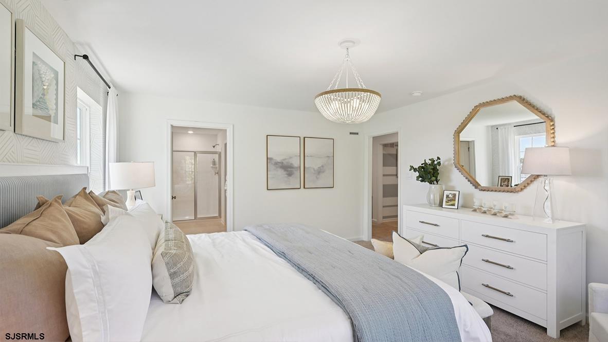 502 Scotty Boulevard, Unit 1202 Rio Grande, NJ 08242 - Photo 29 of 40 a bedroom with a bed a chandelier and dresser