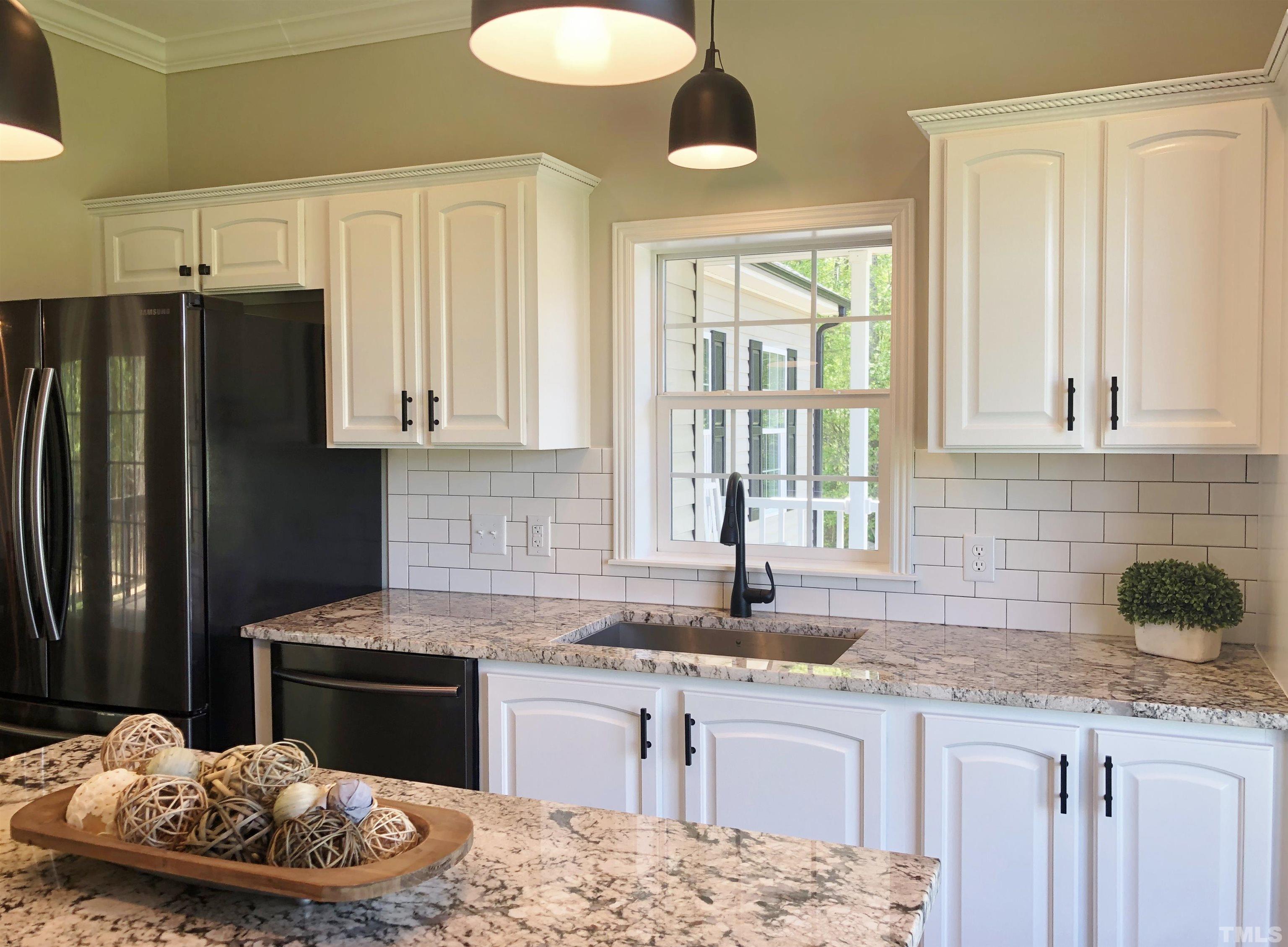 135 Satterfield Farm Road Timberlake, NC 27583 - Photo 5 of 37 a kitchen with granite countertop a sink stainless steel appliances and a counter space