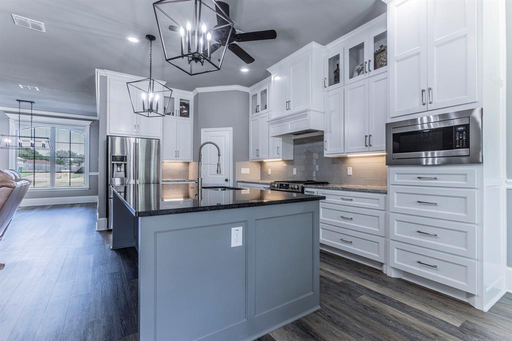 233 Fox Run Lane Robinson, TX 76706 - Photo 5 of 26 a kitchen with stainless steel appliances kitchen island granite countertop a stove and cabinets