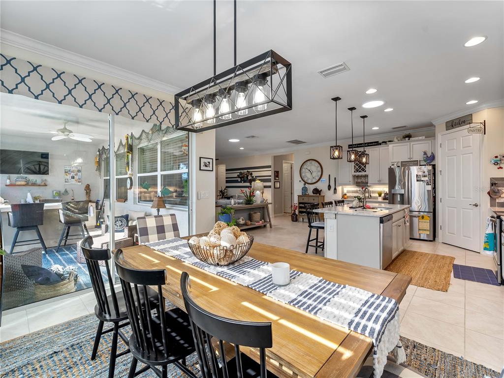 8228 Walbert Street Port Charlotte, FL 33981 - Photo 30 of 66 a dining room with stainless steel appliances kitchen island a table and chairs