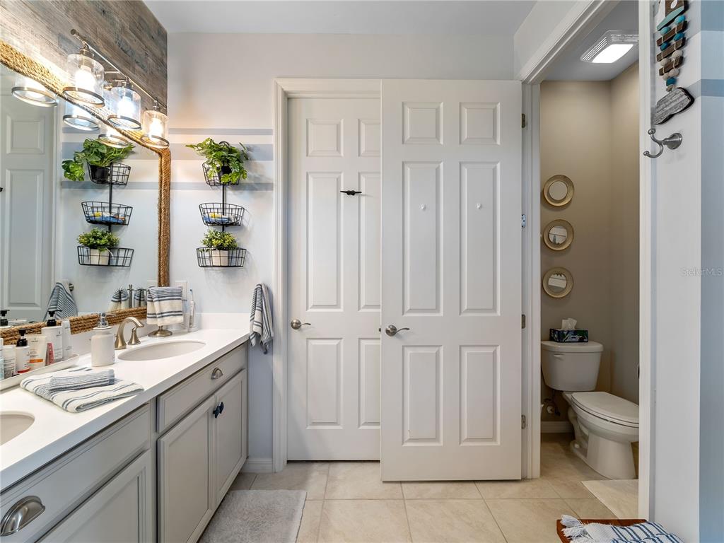 8228 Walbert Street Port Charlotte, FL 33981 - Photo 43 of 66 a spacious bathroom with a double vanity sink a mirror and a toilet
