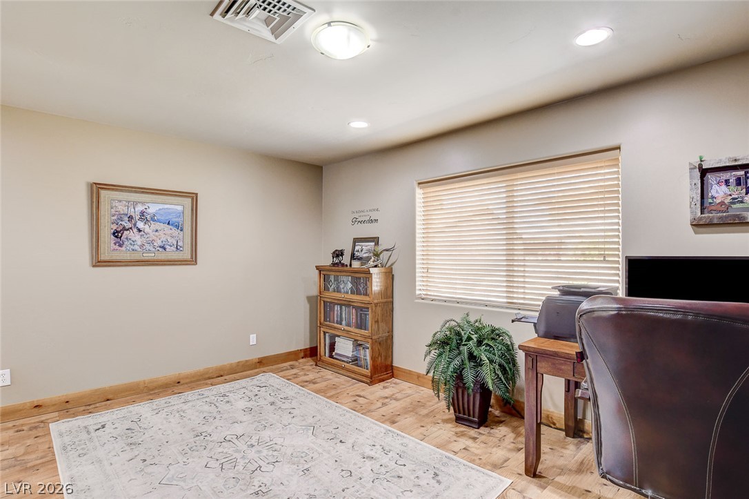 1950 Bowman Road Logandale, NV 89021 - Photo 24 of 81 Well-lit room with wood flooring and blinds offers an inviting space for work or relaxation.