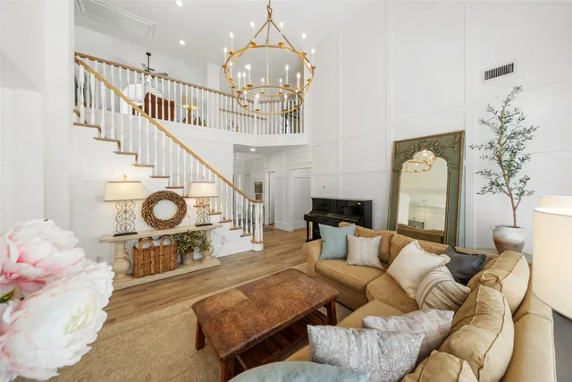 a living room with furniture a fireplace and a chandelier
