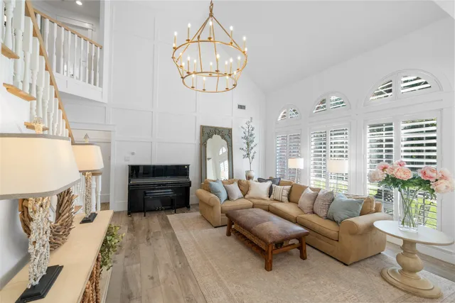 a living room with furniture chandelier and a fireplace