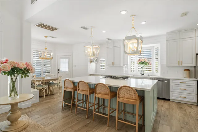 a large kitchen with kitchen island granite countertop a table and chairs