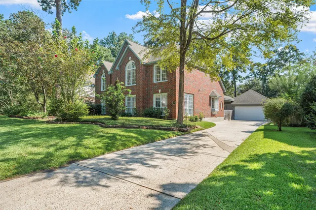 a front view of a house with a yard and an trees