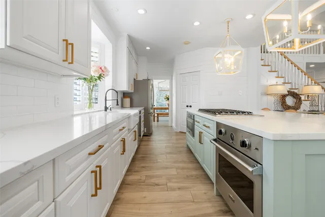 a large white kitchen with stainless steel appliances