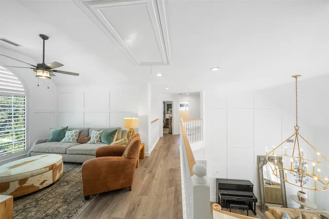 a living room with furniture and a ceiling fan