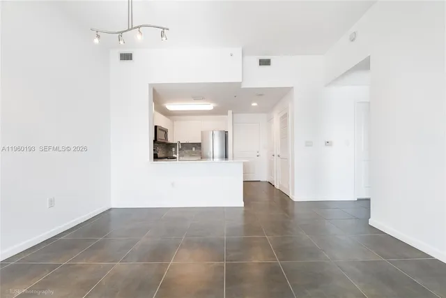 a view of a kitchen with a dishwasher and white cabinets