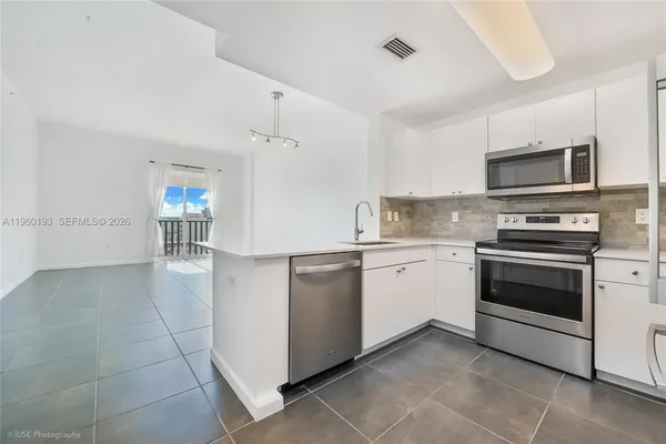 a kitchen with granite countertop cabinets stainless steel appliances and a counter space