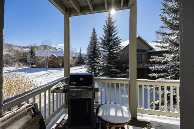 a view of a balcony with chairs and wooden fence