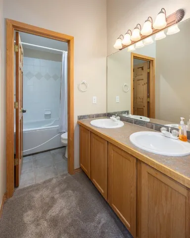 a bathroom with a granite countertop sink mirror and a bathtub