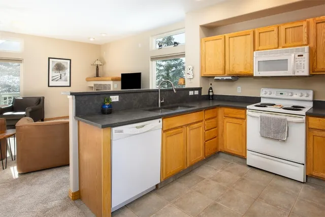 a kitchen with cabinets appliances a sink and a window