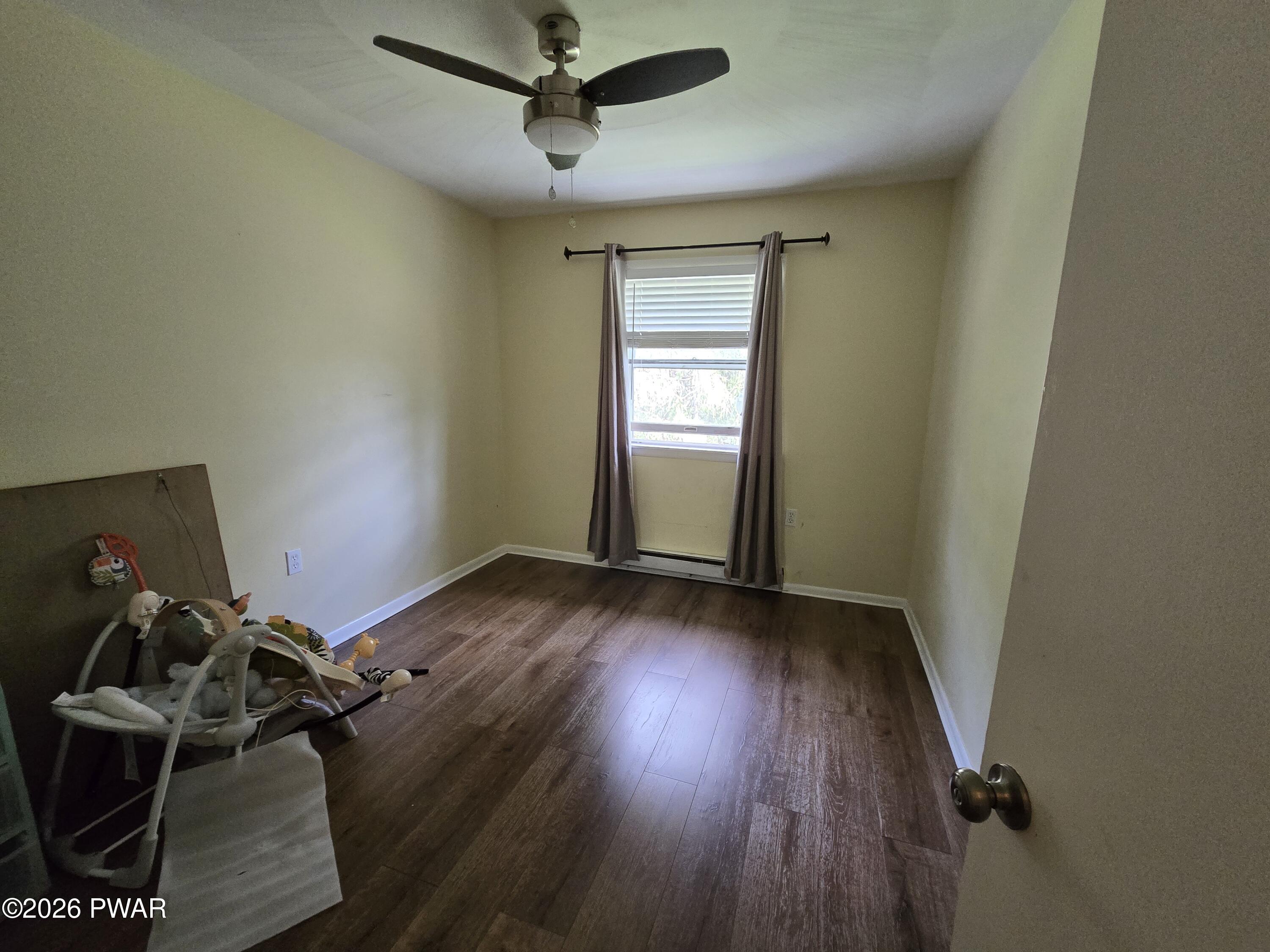 107 Keystone Hls Road, Unit 404 Factoryville, PA 18419 - Photo 20 of 23 an empty room with wooden floor and windows