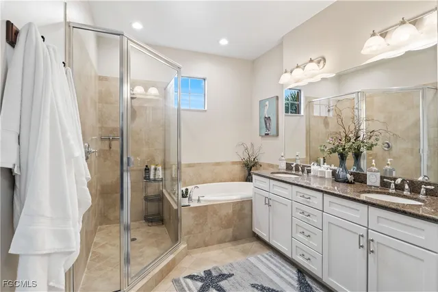 a bathroom with a double vanity sink a mirror a bathtub and shower