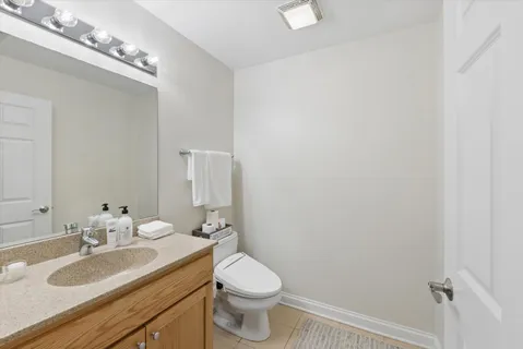 a bathroom with a granite countertop sink a toilet and a mirror