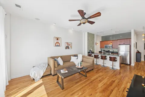 a living room with furniture and a wooden floor
