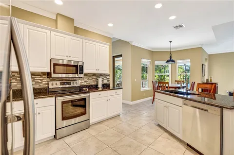 a kitchen with stainless steel appliances granite countertop a stove a sink and a refrigerator