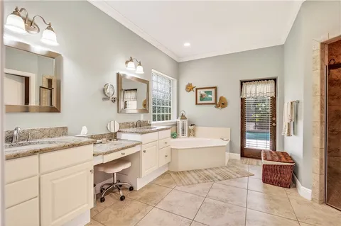 a spacious bathroom with a tub sink and mirror