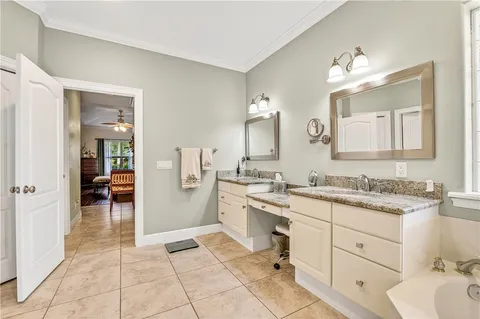 a spacious bathroom with a granite countertop sink a toilet mirror and vanity