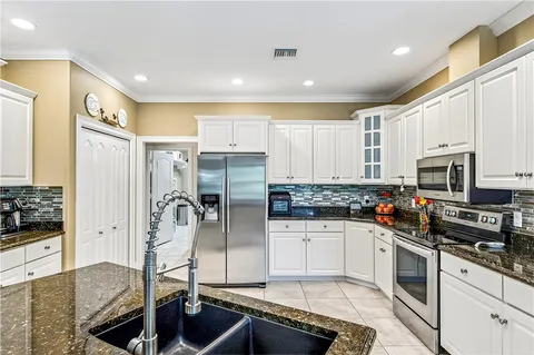 a kitchen with stainless steel appliances a refrigerator sink and stove