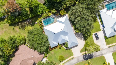 an aerial view of a house with swimming pool and garden